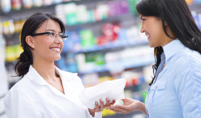 Pharmacist with client at a drugstore
